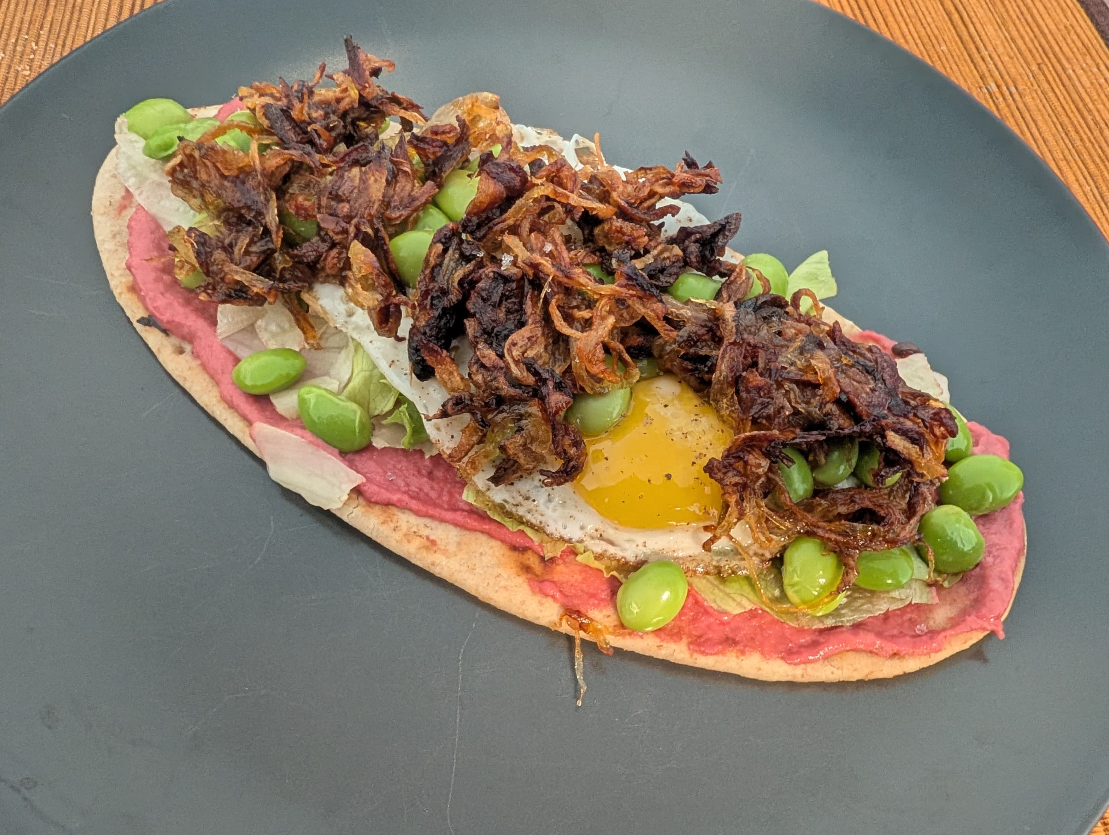 Flatbread with Beetroot Hummus, Fried Egg, Edamame, and Caramelized Onions Rocely Recipe